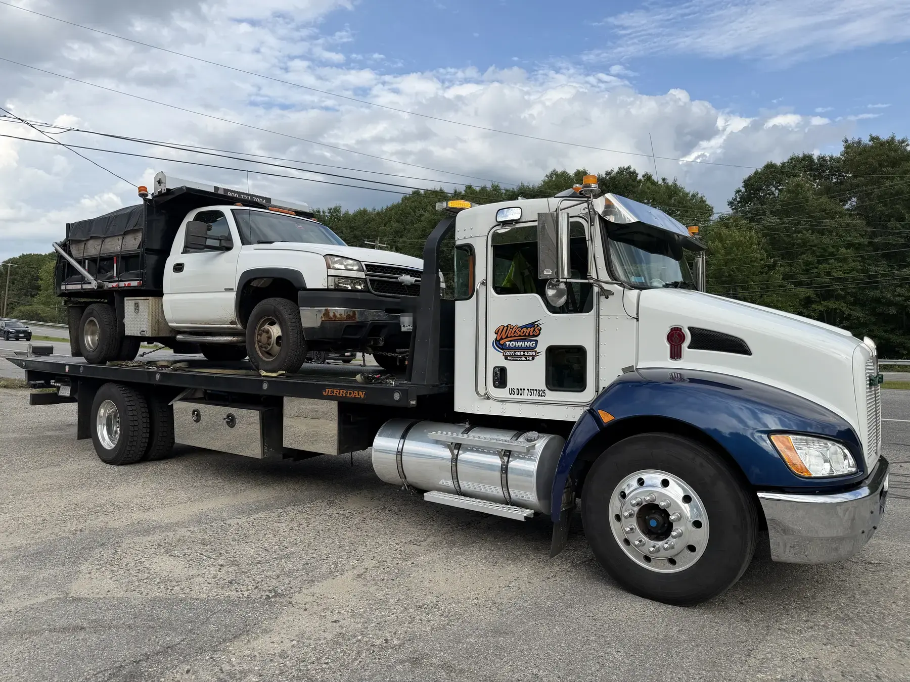 Wilson’s Towing transporting a work truck in Central Maine